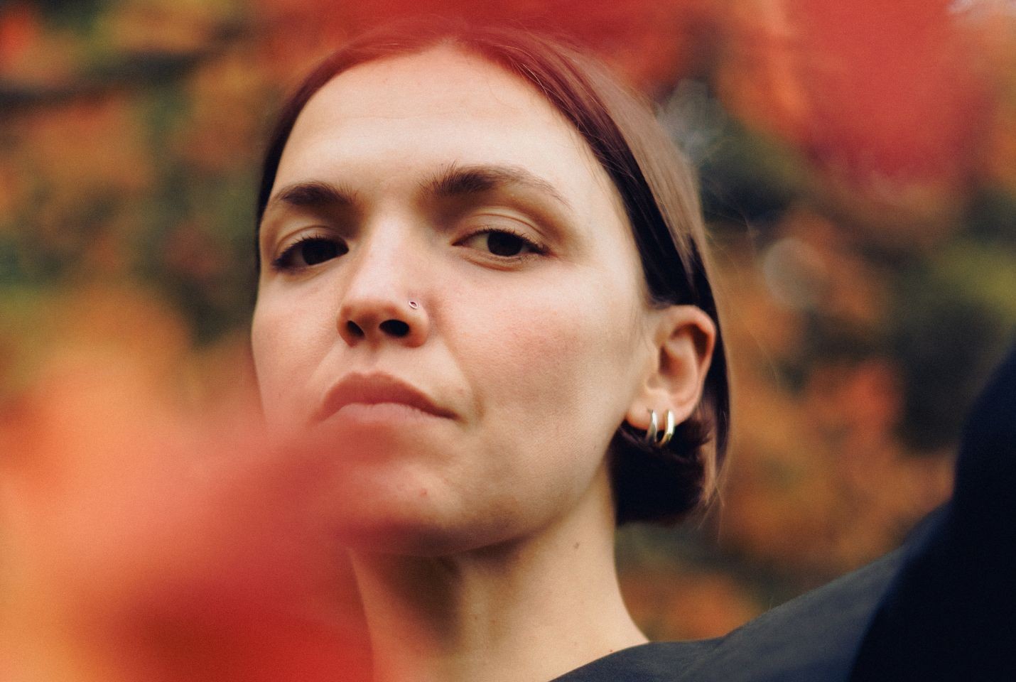 A woman with short brown hair and two silver hoop earrings in her ear